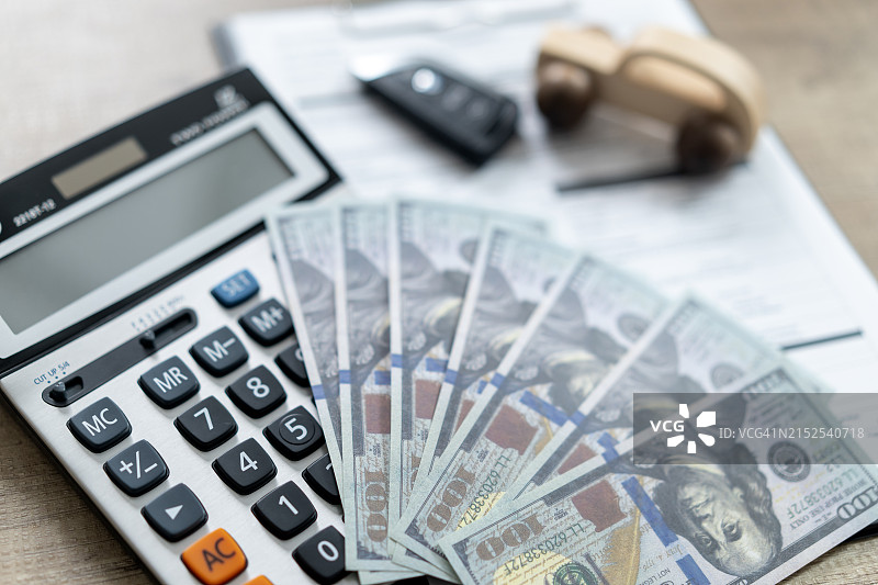 汽车贷款概念：玩具车、钥匙、计算器和现金图片素材
