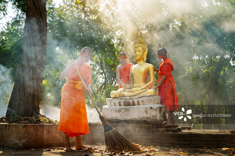 僧侣和小沙弥的日常生活：清洁佛像，打扫落叶图片素材