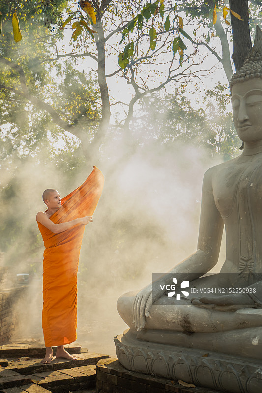 僧侣在佛像附近穿着长袍图片素材