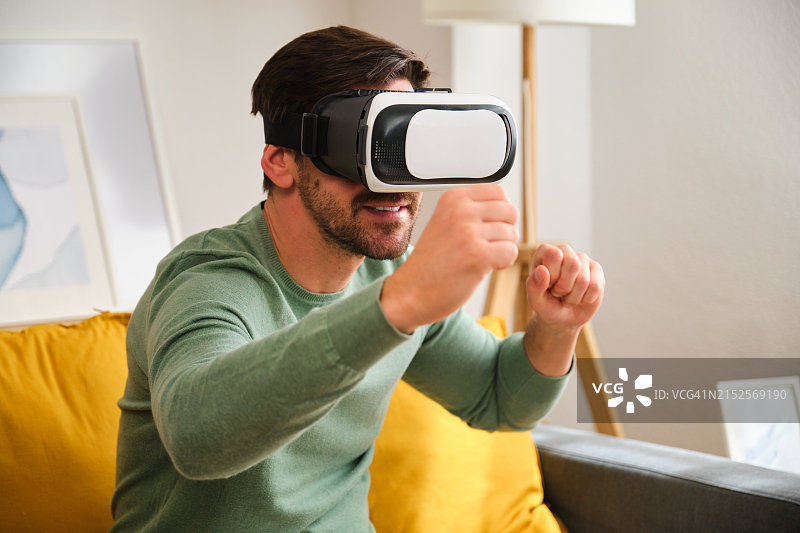 男人戴着VR头显玩电子游戏图片素材
