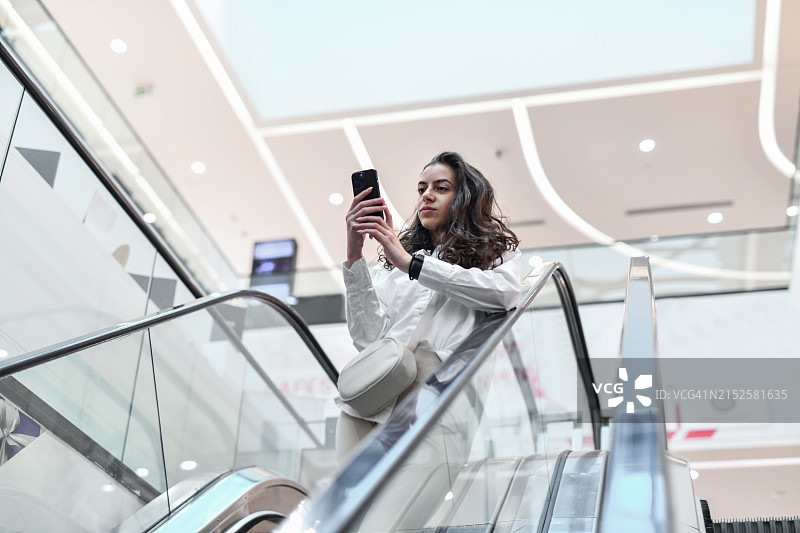 女性在商场扶梯上自拍图片素材