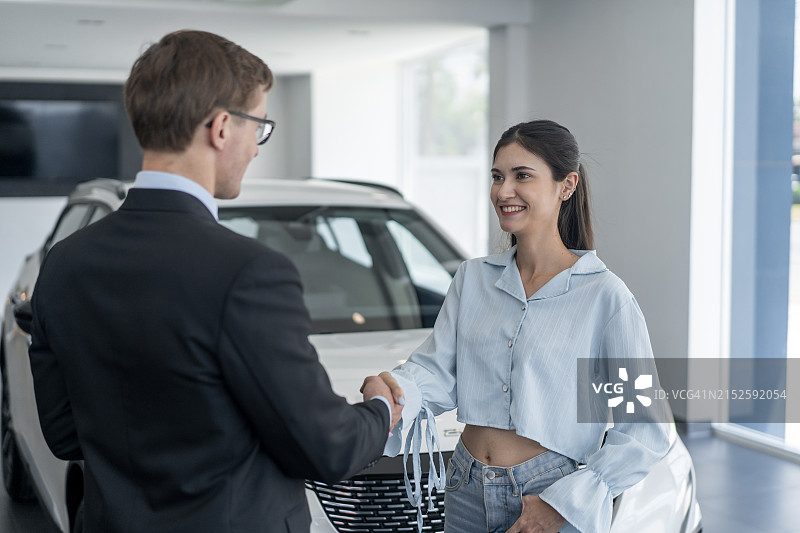 汽车销售员向女士展示新车图片素材