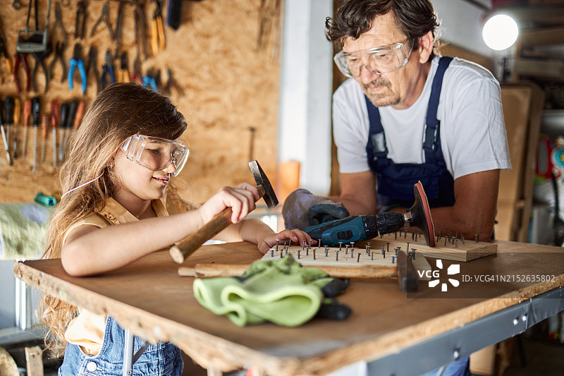 祖父和孙女在车库里修理东西图片素材