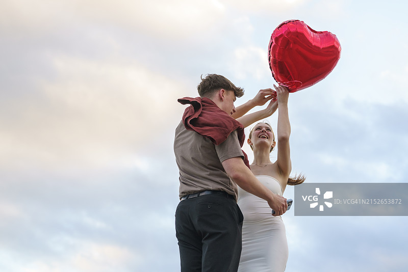 日落时摆姿势的开朗年轻情侣肖像图片素材