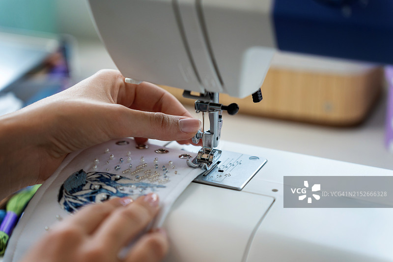 年轻女子使用机器刺绣图片素材