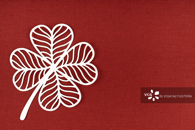 红色织物背景上的白色纸质叶子雕刻，带有复制空间图片素材