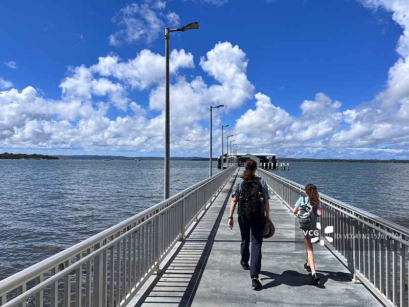 母亲和女儿在夏季假期于码头上散步图片素材