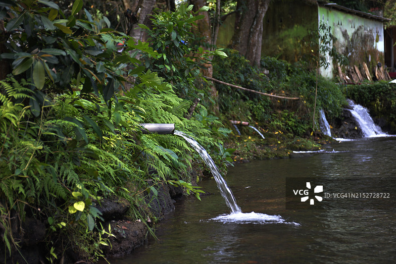 从管道流向河流的水图片素材