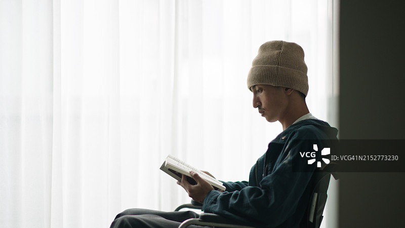 坐在轮椅上读书的病人图片素材