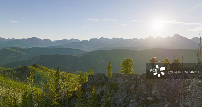 老年夫妇在日出时一起探索山顶图片素材