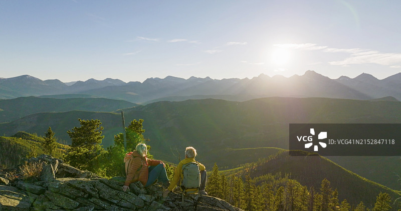 老年夫妇在日出时一起探索山顶图片素材