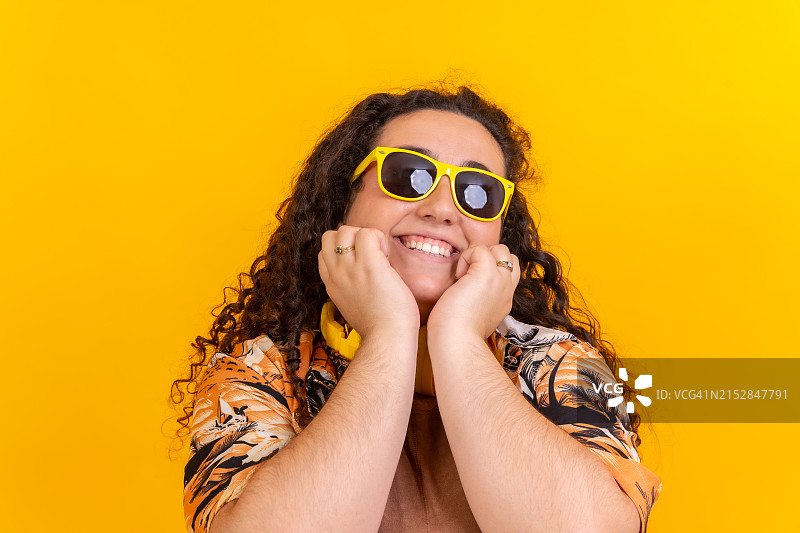 戴着太阳镜和夏装的可爱超重女人对着镜头微笑图片素材