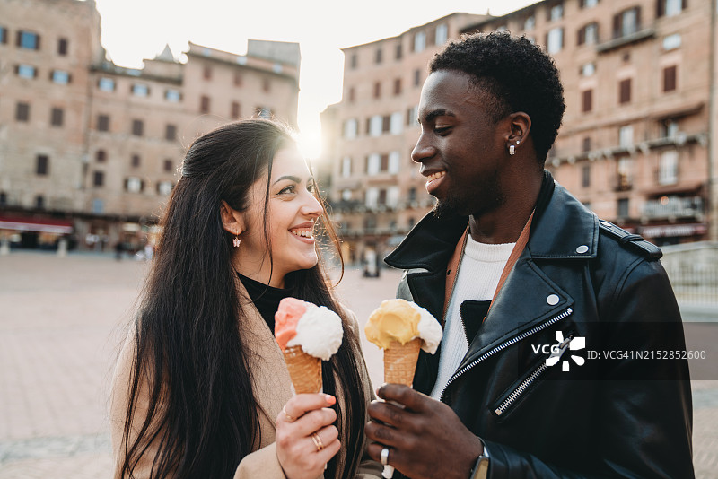 年轻夫妇在锡耶纳日落时分吃冰淇淋图片素材