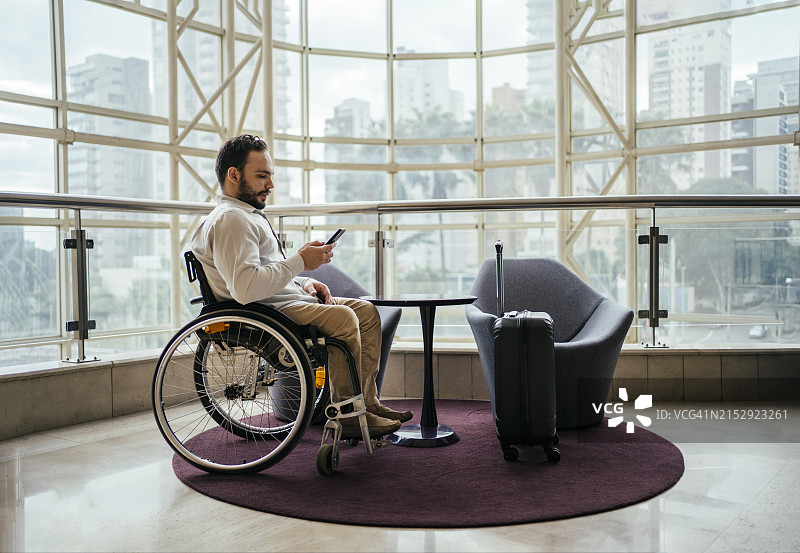 坐轮椅在酒店工作的商务男人图片素材