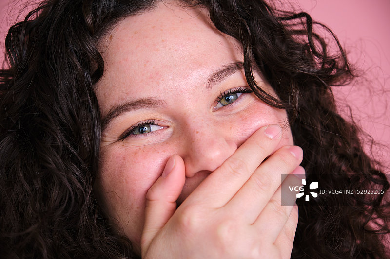 卷发女人笑着捂住嘴图片素材
