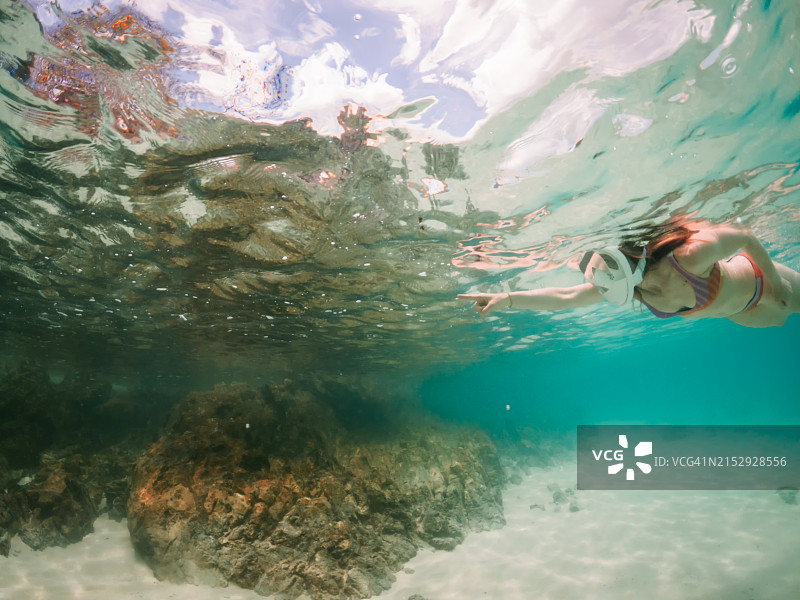 女人在靠近异国情调岛屿的热带水域浮潜图片素材