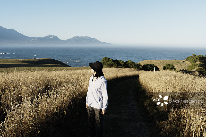 亚洲女游客走在凯库拉半岛步道上，凝视远方图片素材
