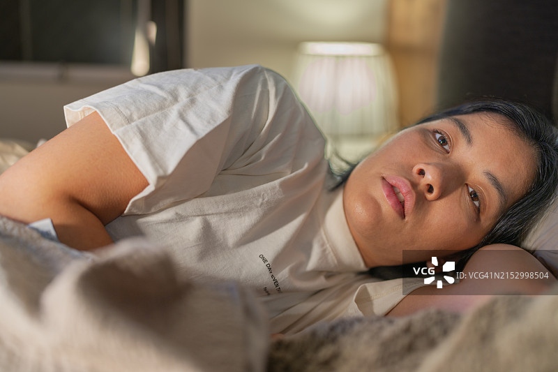 失眠的冰冷女人躺在床上图片素材
