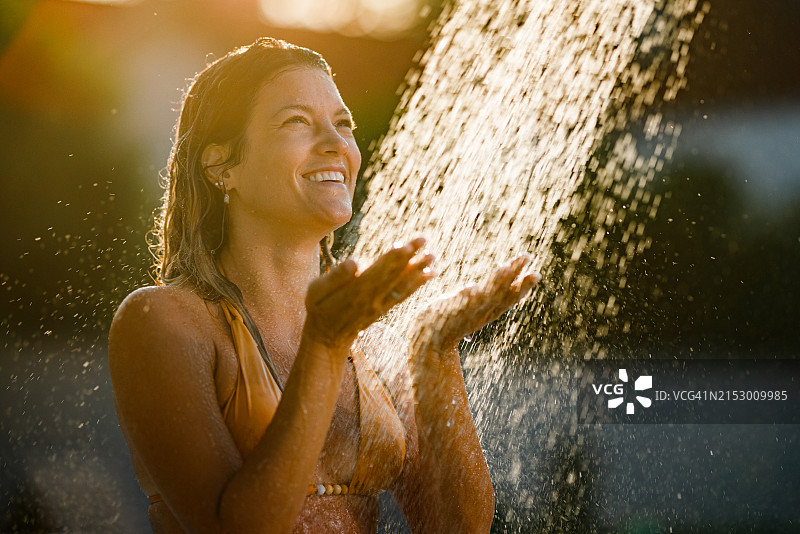 快乐的女人在自然环境中淋浴图片素材