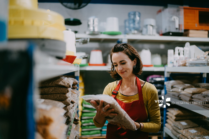 在商店工作的女人正在补货零售展示图片素材