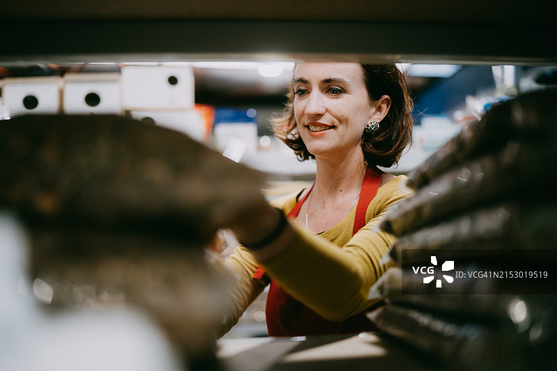 在商店工作的女人正在补货零售展示图片素材