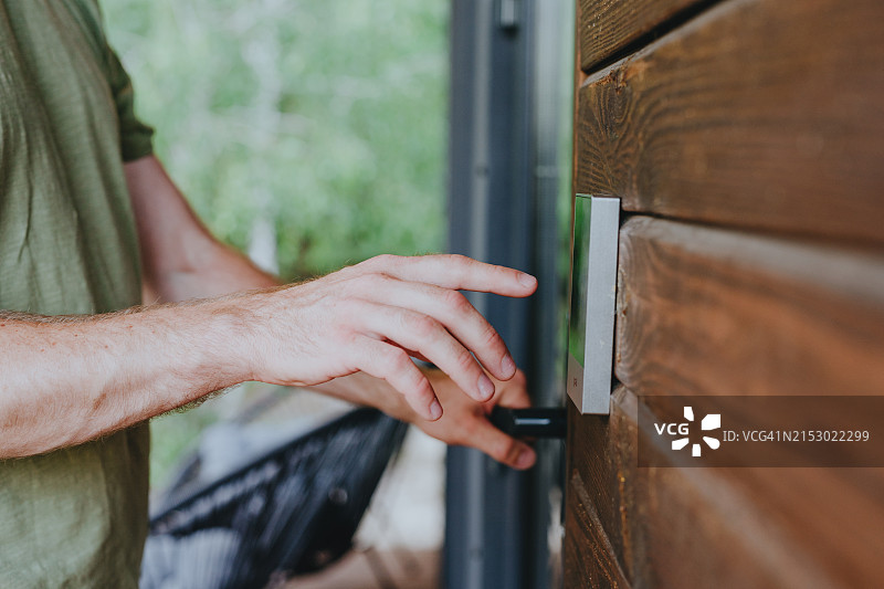 青年男子在门上数字密码锁输入密码图片素材