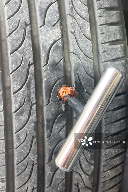 轮胎上扎着钉子，轮胎已磨损并有孔洞图片素材