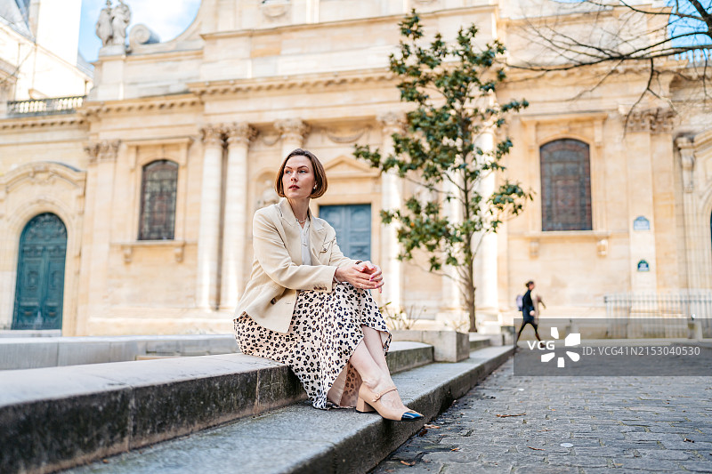 坐在巴黎索邦大学前的街上的年轻女人图片素材