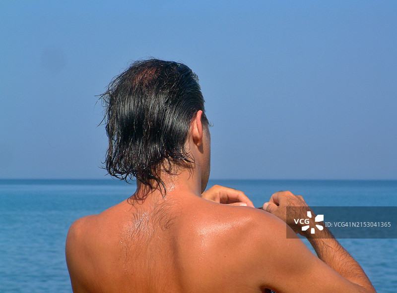 游泳后男子站在希腊海滩上特写图片素材