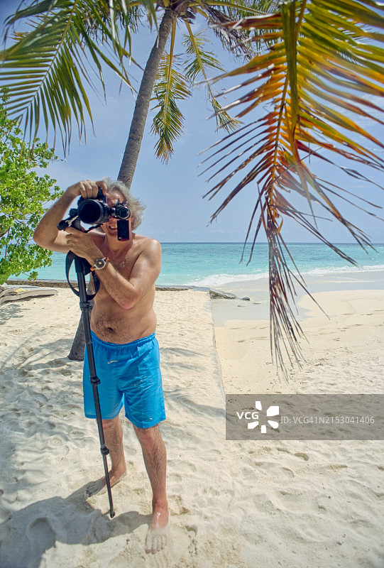 在海滩上用相机拍摄的专业摄影师图片素材