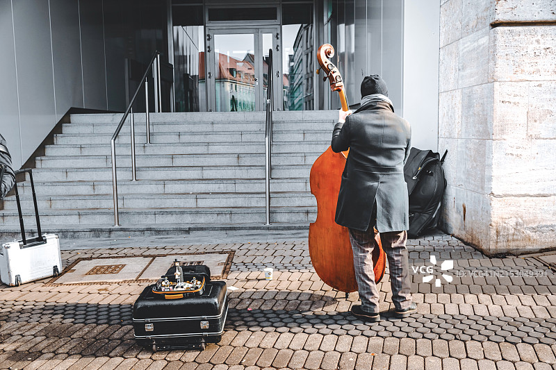 在德国纽伦堡市的购物区，一名男子演奏爵士乐的后视图图片素材