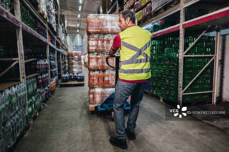 中年男人在超市里拉着手推车图片素材