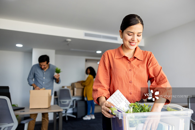 商务女人和她的团队搬办公室，用箱子打包图片素材