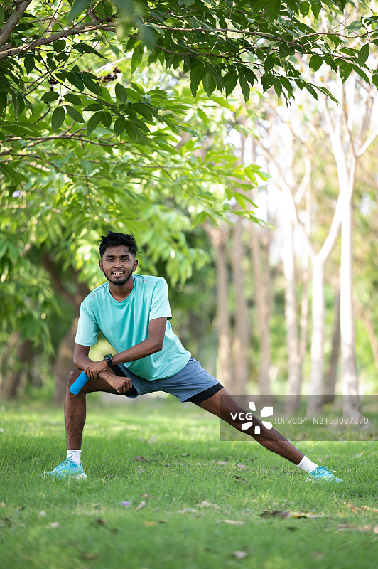 在公园拉伸小腿肌肉的亚洲男人图片素材