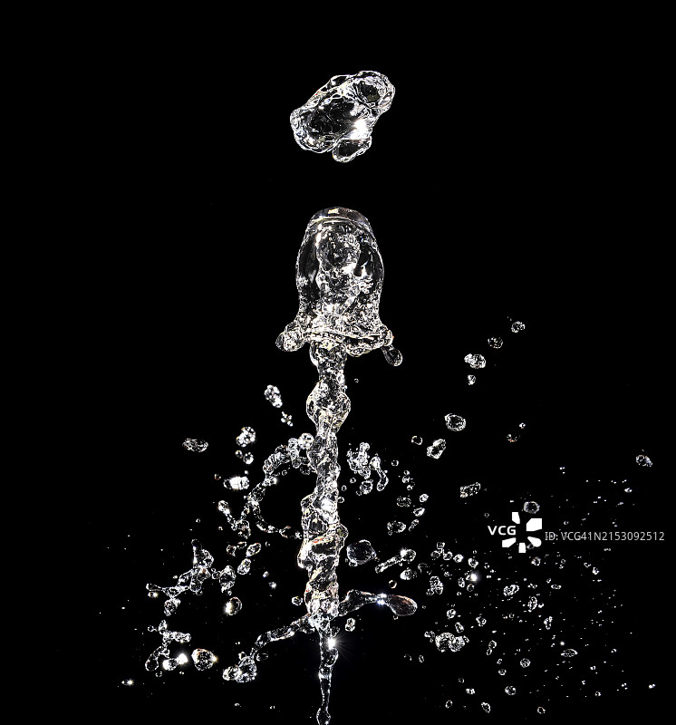 黑色背景上，自然水花飞溅和水滴运动图片素材