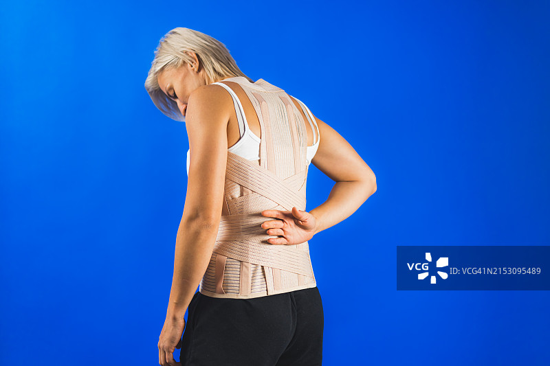 蓝色背景下胃痛的女人图片素材