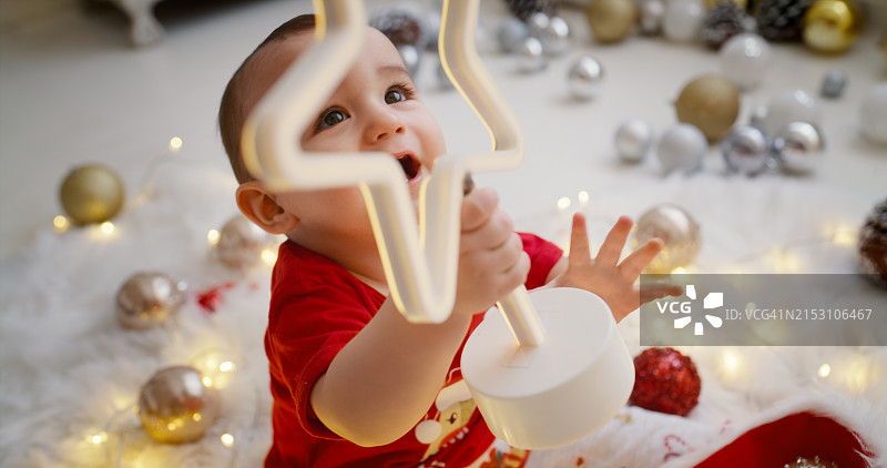 圣诞节期间，家中装饰的星星和婴儿，充满节日的欢乐。婴儿和儿童在圣诞节与家人一起玩耍的温馨记忆图片素材
