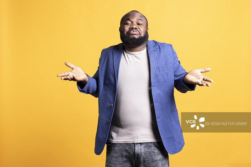 站在黄色背景前的年轻男人图片素材