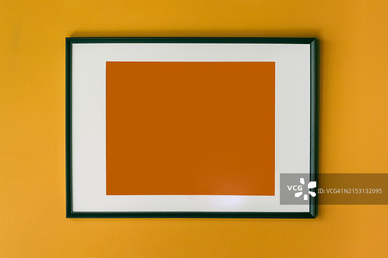 简约艺术画框，亮橙色方块安装在亮黄色墙壁上图片素材