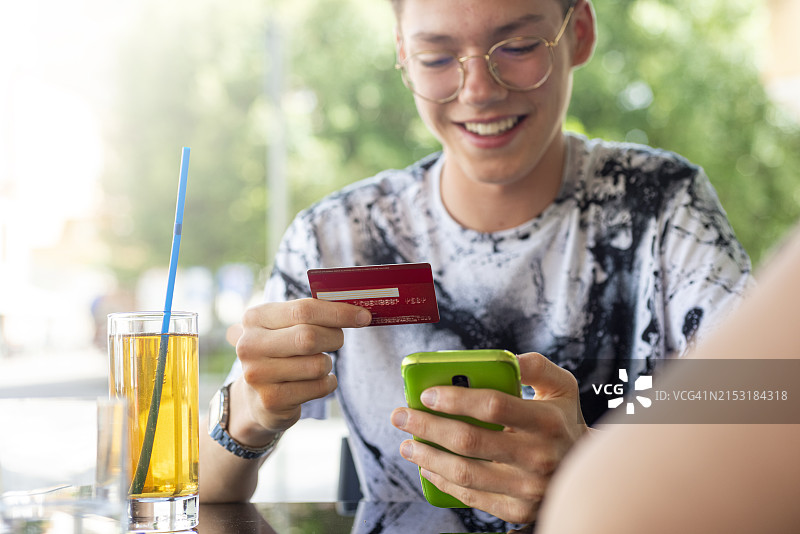 男人用智能手机和信用卡进行网上购物图片素材