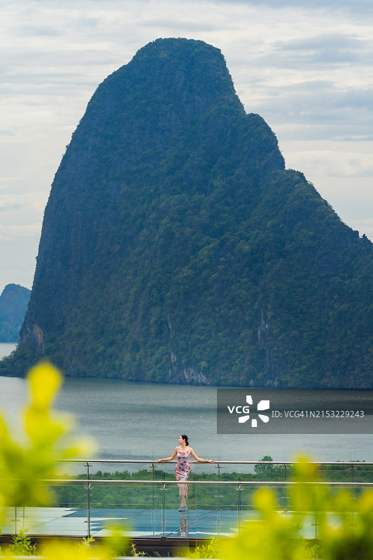 日出时分，在高架玻璃桥上欣赏攀牙湾山景和穿着裙子的女人图片素材