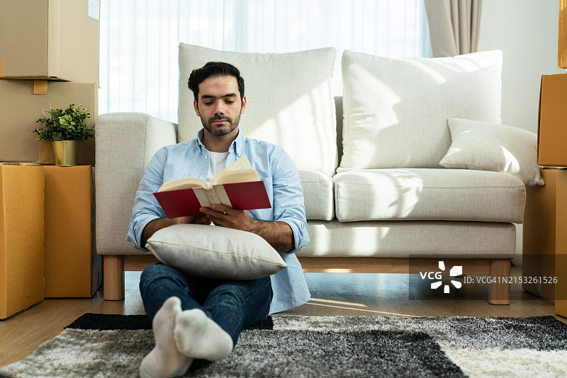 男人在客厅地板上看书图片素材