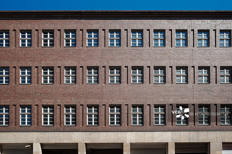 具有对称排列多扇窗户的红砖建筑立面图片素材