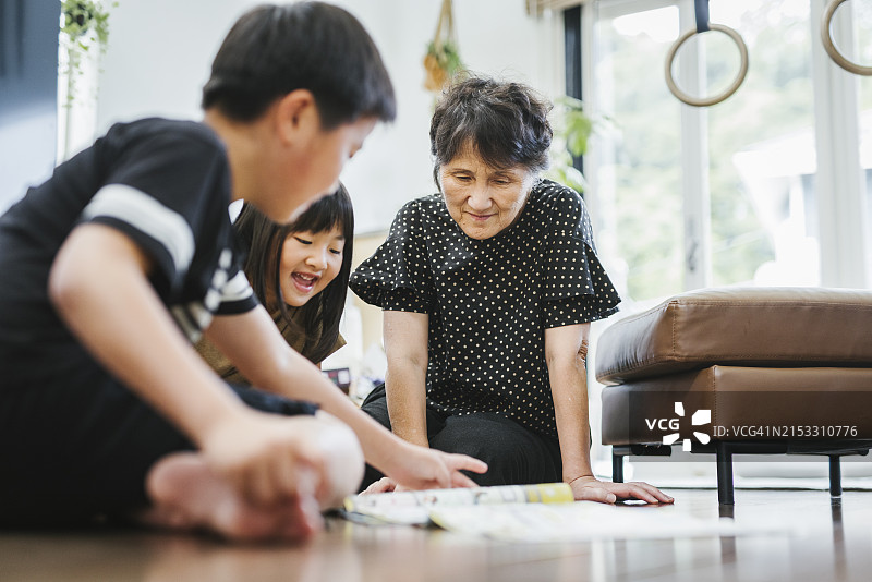 亚洲奶奶和孙子孙女在客厅玩耍图片素材
