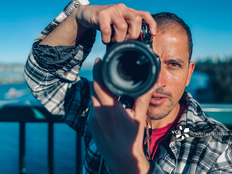 在狮门大桥上手持相机的男人肖像图片素材