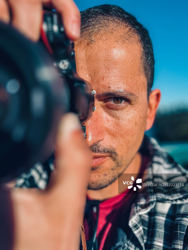 在狮门大桥上手持相机的男人肖像图片素材