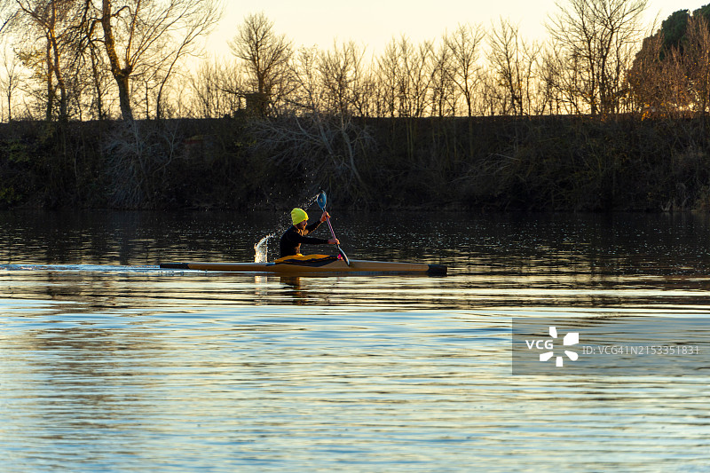 年轻男子在杜罗河日落时划独木舟训练图片素材