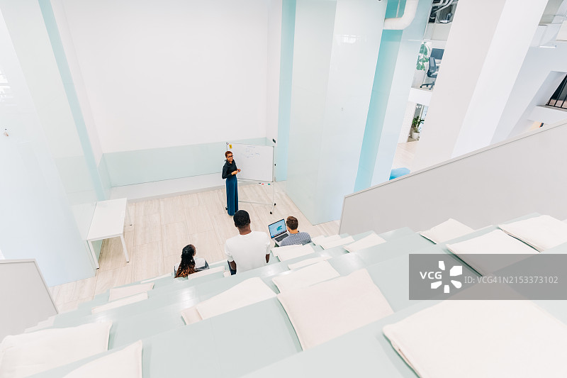 自信的女商人，在演讲厅里在挂图上书写图片素材