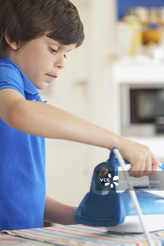 熨衣服的年轻男孩特写图片素材