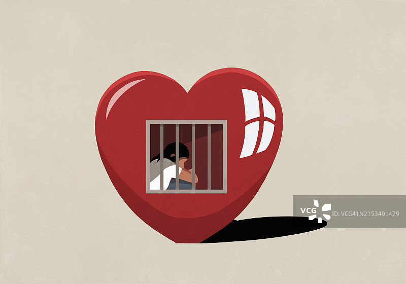 悲伤的女人坐在象征内心牢笼的铁栅栏后图片素材